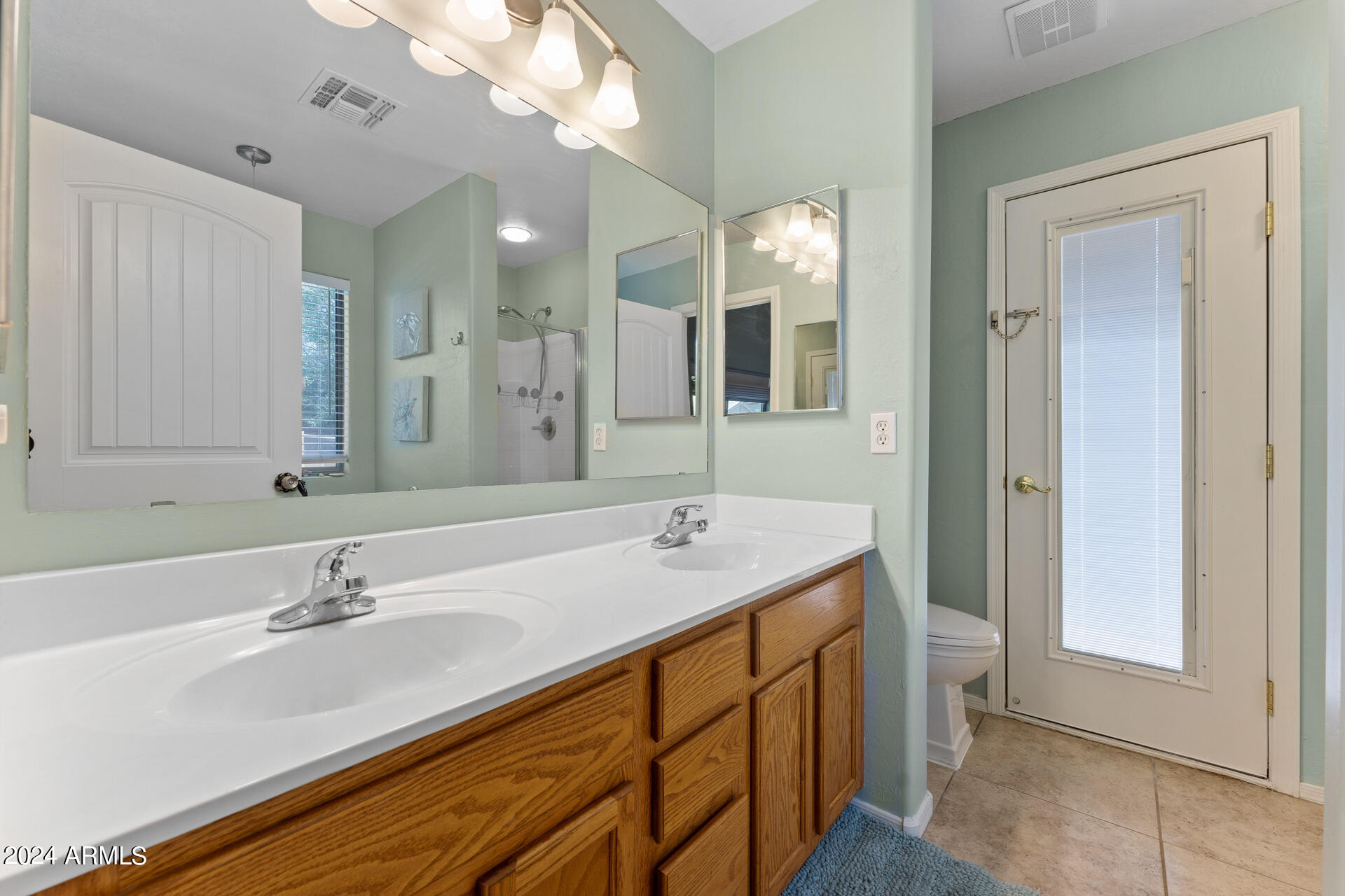 2331 West Apollo Road Phoenix, AZ 85041 - Photo 17 of 26 a bathroom with a double vanity sink and a mirror