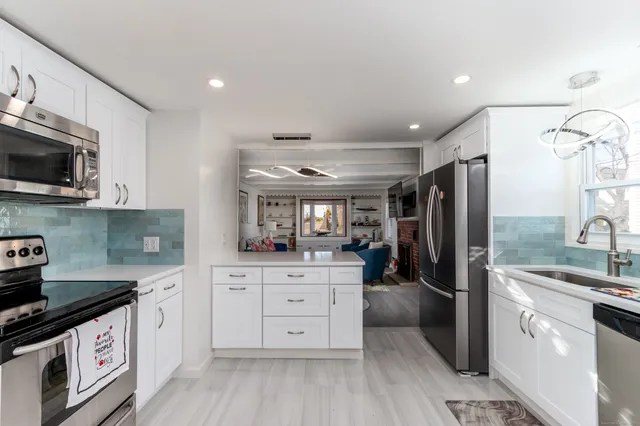 a kitchen with stainless steel appliances a stove refrigerator sink and microwave