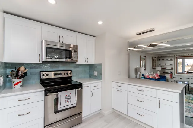 a kitchen with white cabinets stainless steel appliances and sink