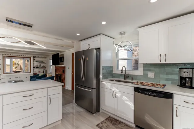 a kitchen with a refrigerator sink and white cabinets