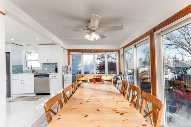 a dining hall with stainless steel appliances kitchen island granite countertop a stove and white cabinets