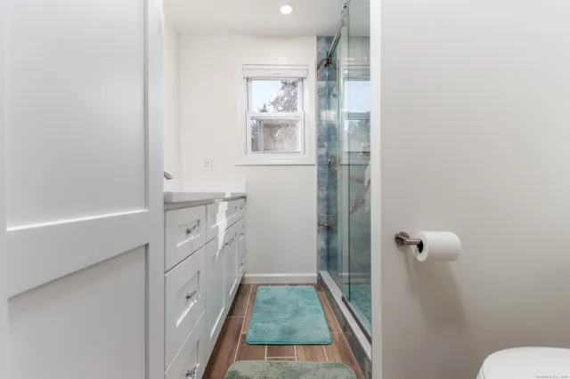 a bathroom with a sink and mirror with toilet