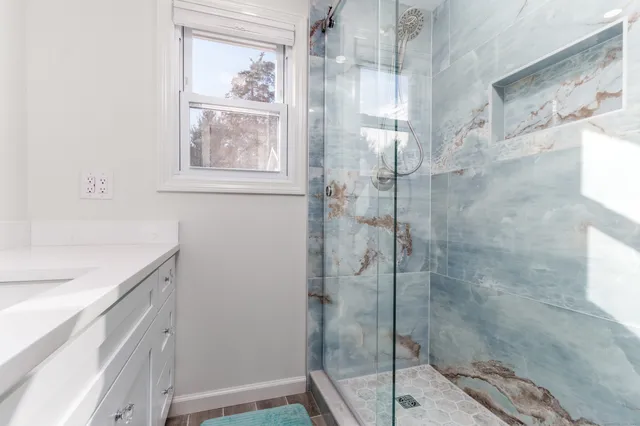 a bathroom with a granite countertop sink a shower and a mirror
