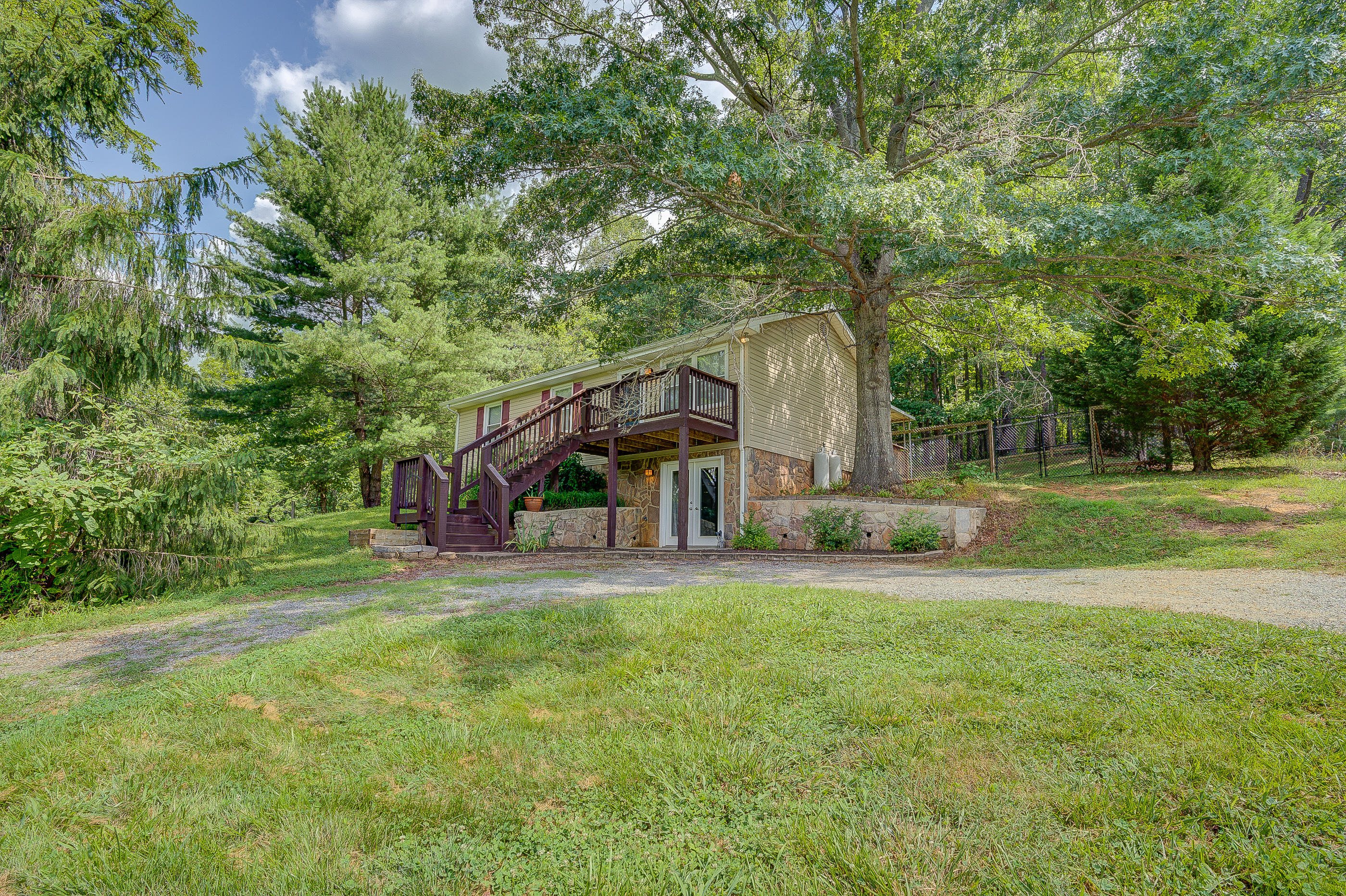 1405 Bore Auger Road Blue Ridge, VA 24064 - Photo 2 of 22 a view of a house next to a big yard and large trees