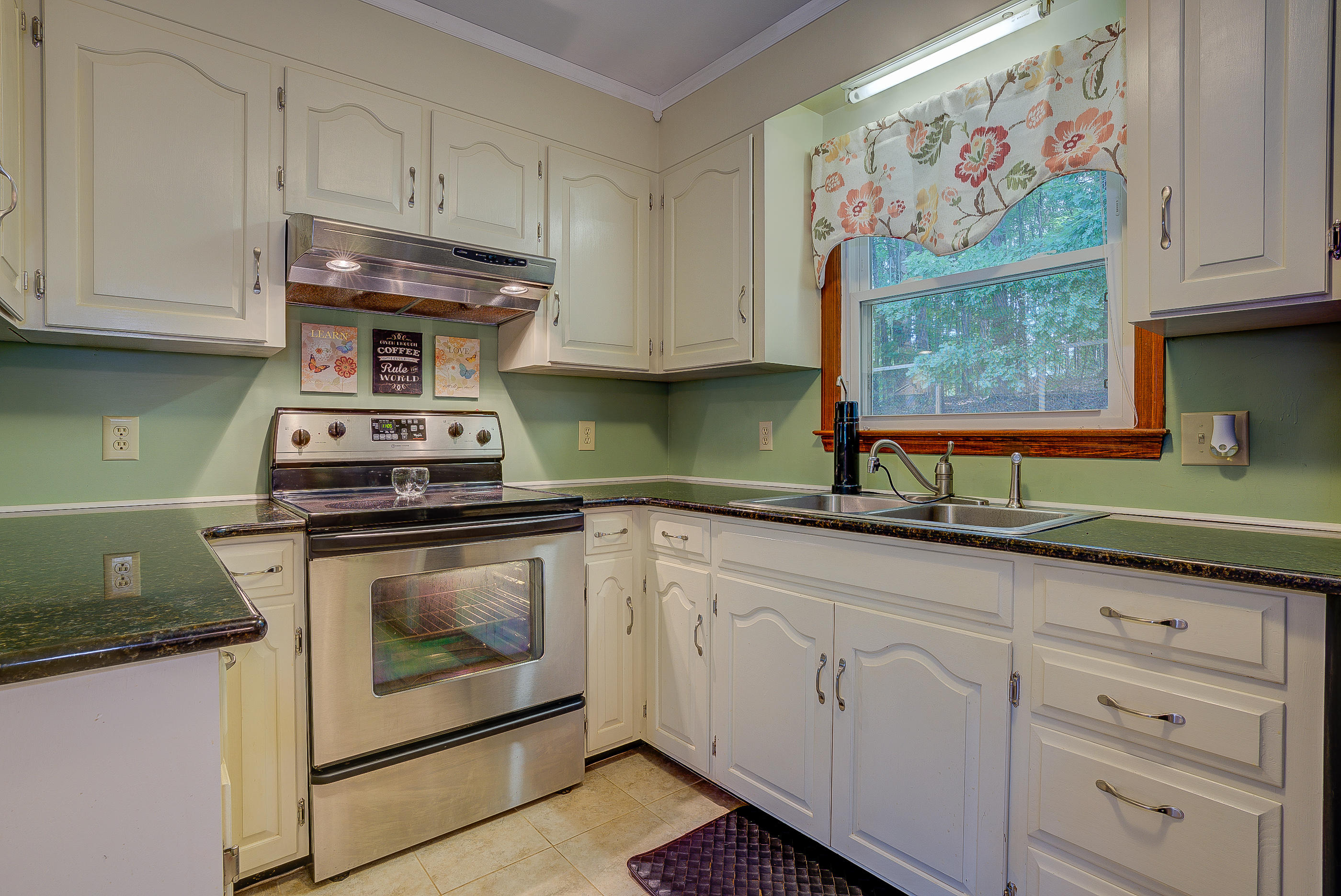 1405 Bore Auger Road Blue Ridge, VA 24064 - Photo 9 of 22 a kitchen with granite countertop white cabinets and stainless steel appliances
