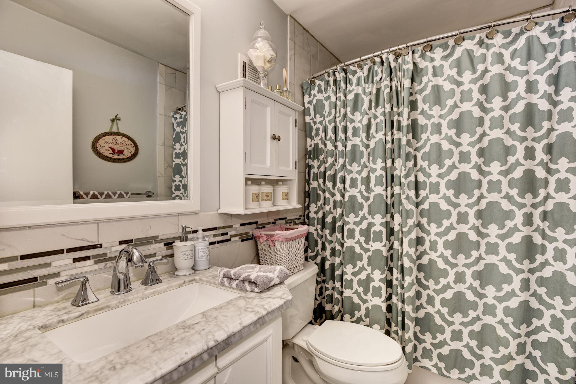 1851 Wainwright Drive Reston, VA 20190 - Photo 15 of 26 a bathroom with a granite countertop sink a toilet and a mirror