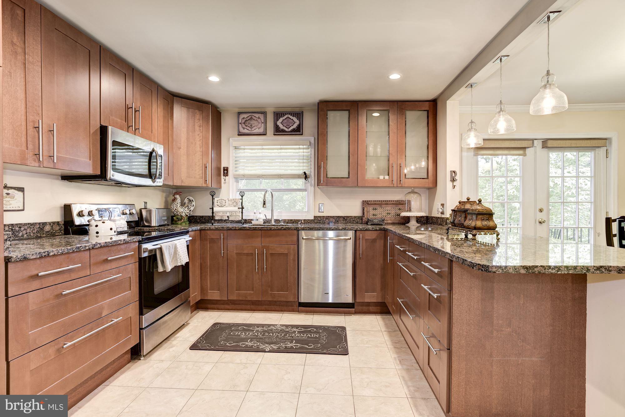1851 Wainwright Drive Reston, VA 20190 - Photo 9 of 26 a kitchen with stainless steel appliances granite countertop a stove a sink and a microwave
