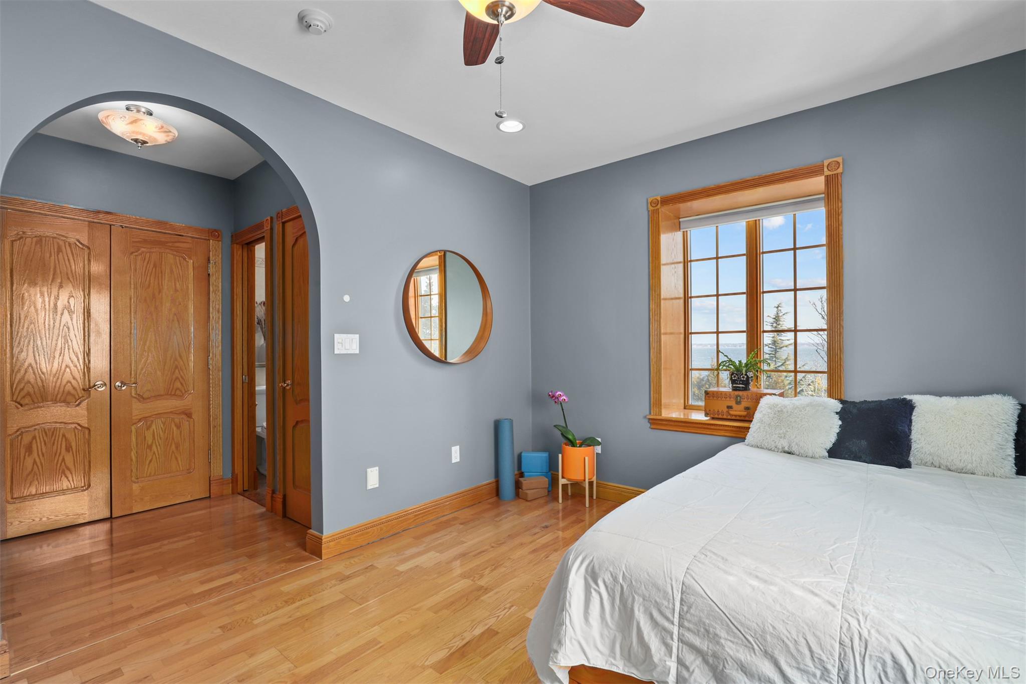 3407 Country Club Road Bronx, NY 10465 - Photo 26 of 34 Bedroom featuring arched walkways, light wood-style flooring, baseboards, and ceiling fan