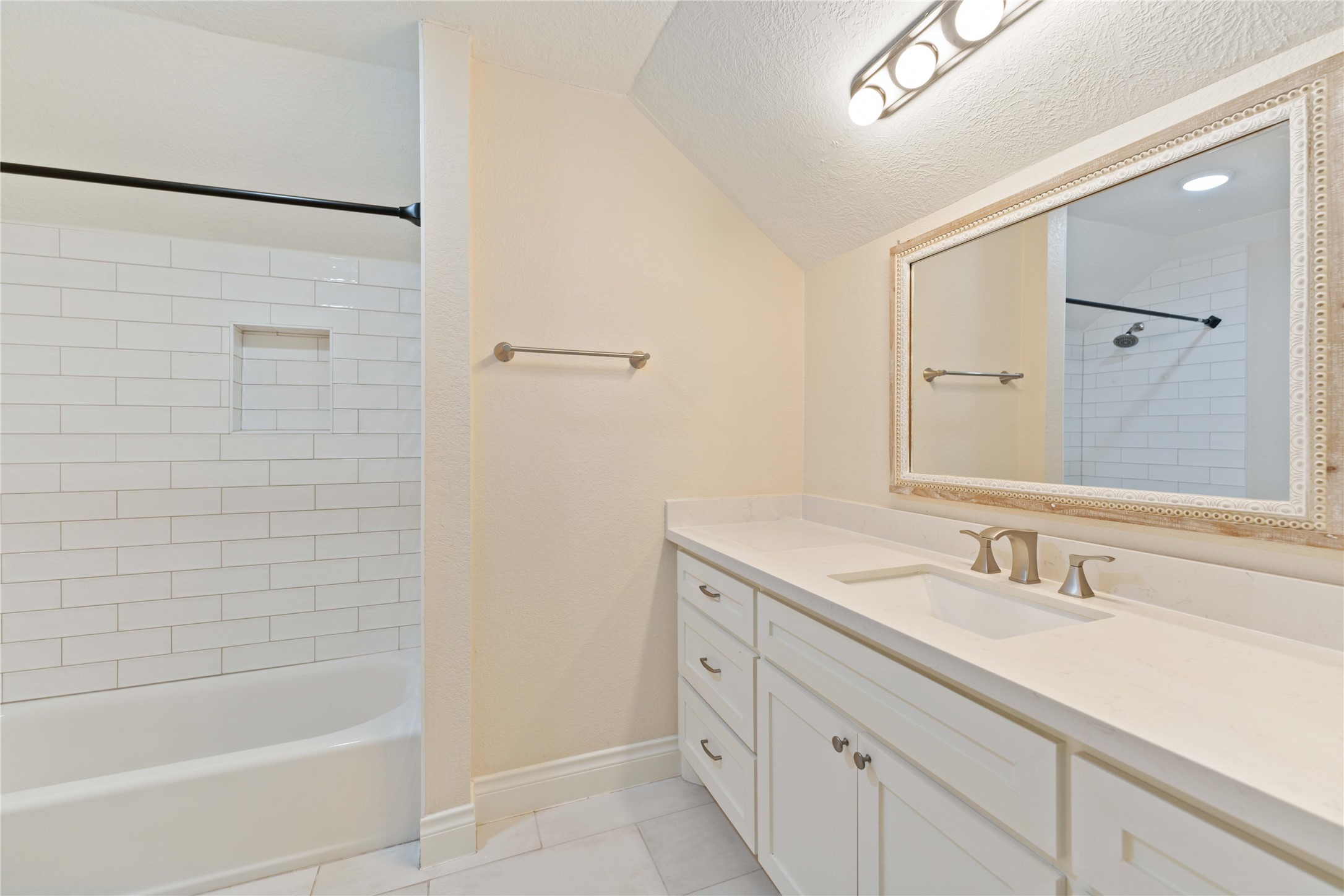 2631 Persa Street Houston, TX 77098 - Photo 17 of 25 a bathroom with a granite countertop sink a mirror and a bathtub