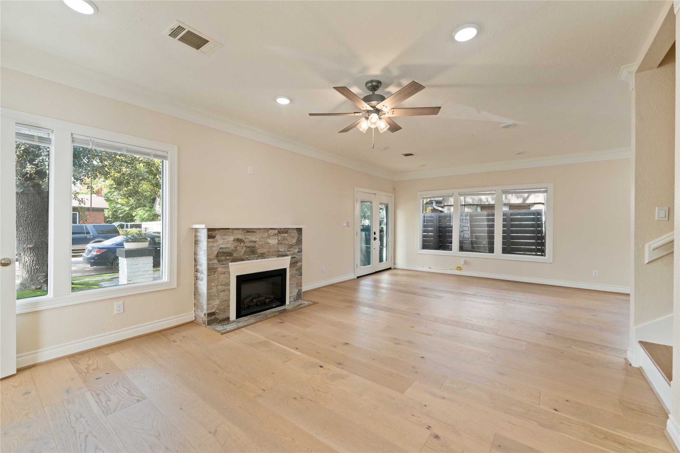 2631 Persa Street Houston, TX 77098 - Photo 10 of 25 an empty room with windows fireplace and fan