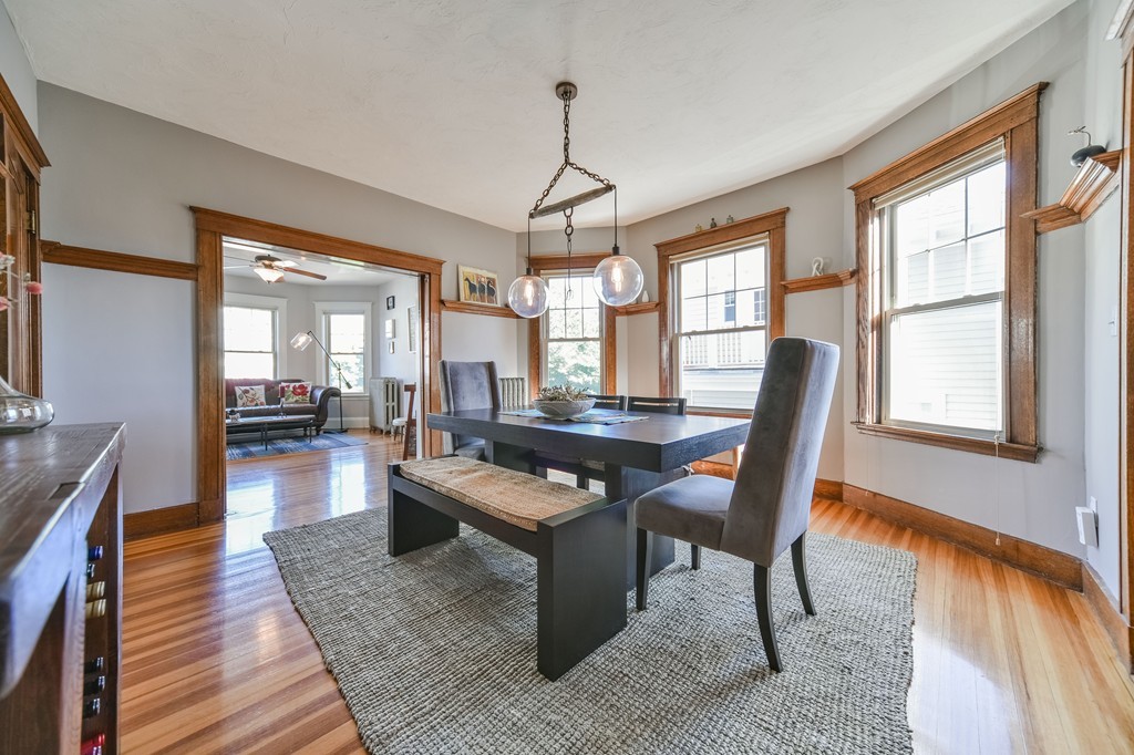 99 Parkton Road, Unit 2 Boston, MA 02130 - Photo 4 of 19 a dining room with wooden floor a chandelier a wooden table and chairs