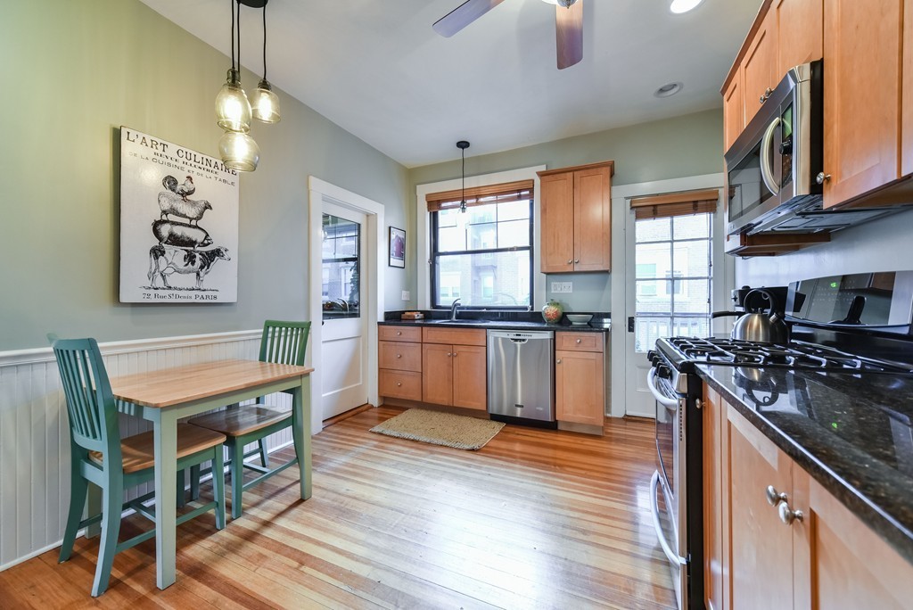99 Parkton Road, Unit 2 Boston, MA 02130 - Photo 7 of 19 a kitchen with stainless steel appliances granite countertop a stove top oven a sink dishwasher a dining table and chairs with wooden floor
