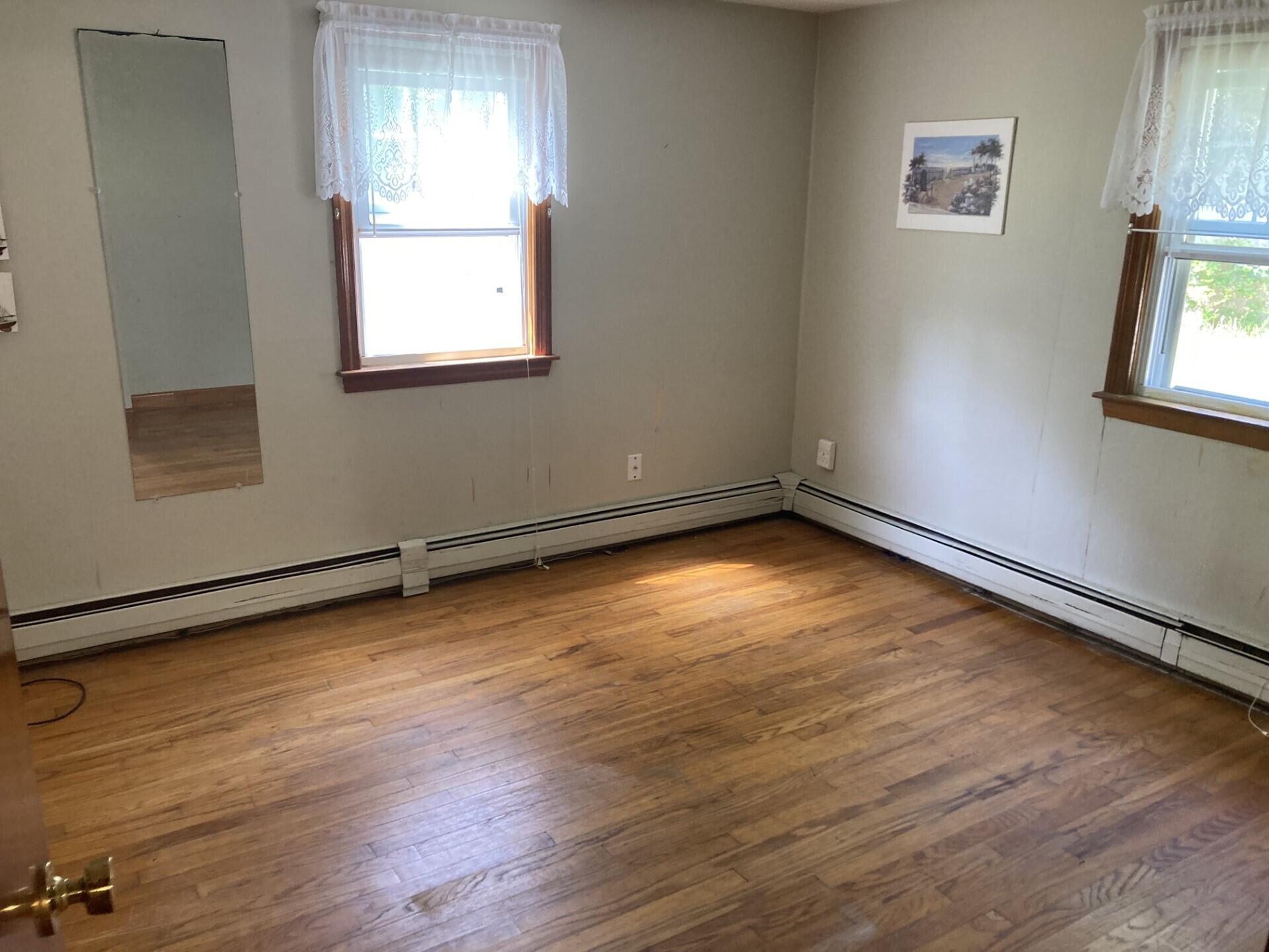 45 Blue Jay Drive Hyannis, MA 02601 - Photo 17 of 18 an empty room with wooden floor and windows