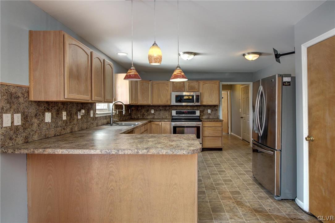 1095 Clover Road South Long Pond, PA 18334 - Photo 4 of 27 a kitchen with stainless steel appliances granite countertop a refrigerator a stove a sink and a microwave