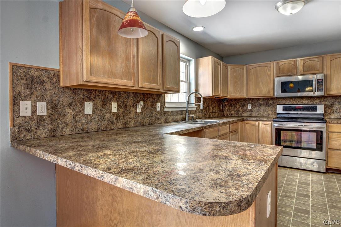 1095 Clover Road South Long Pond, PA 18334 - Photo 5 of 27 a kitchen with granite countertop a sink a stove and a microwave