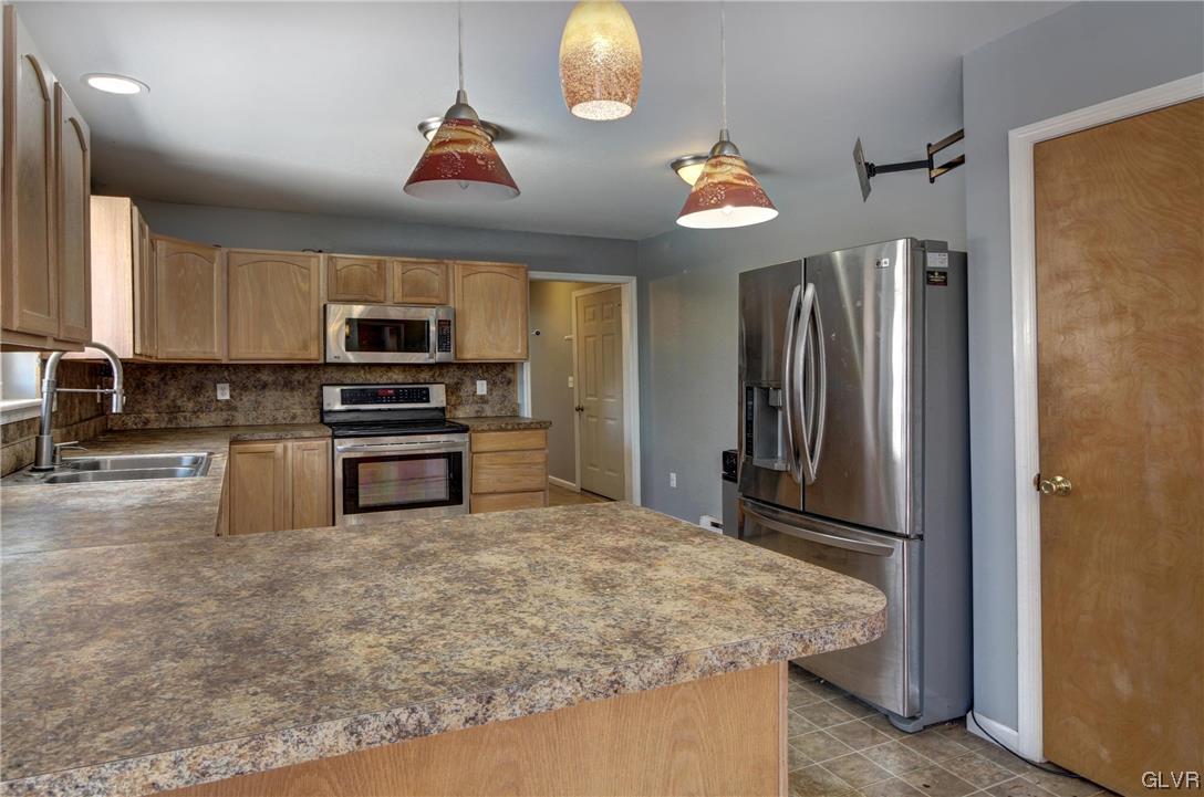 1095 Clover Road South Long Pond, PA 18334 - Photo 7 of 27 a kitchen with stainless steel appliances granite countertop a refrigerator a stove and a sink