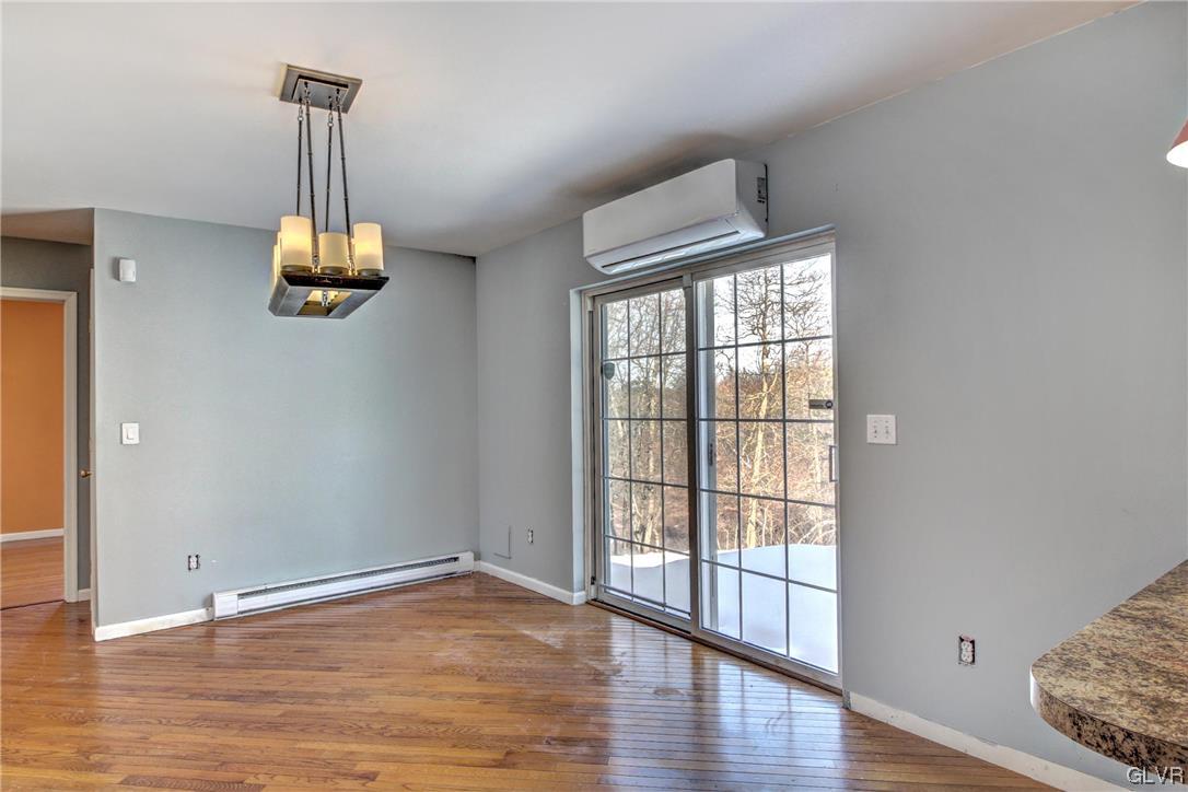 1095 Clover Road South Long Pond, PA 18334 - Photo 9 of 27 a view of a room with wooden floor chandelier and windows
