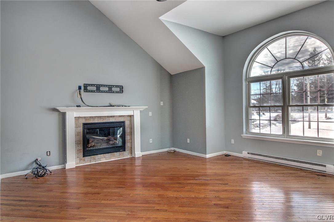 1095 Clover Road South Long Pond, PA 18334 - Photo 10 of 27 an empty room with wooden floor fire place and windows