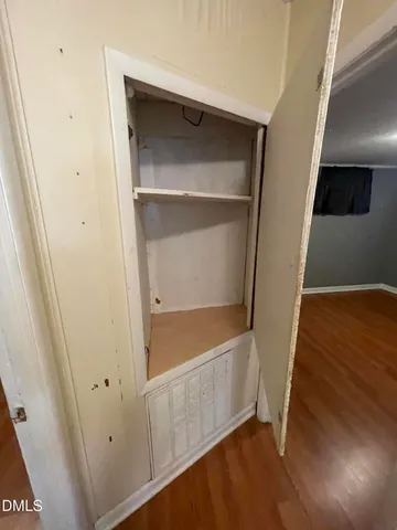 an empty room with wooden floor and closet