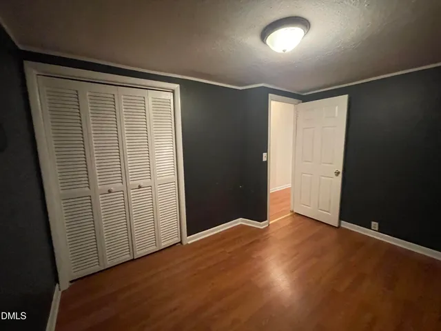 an empty room with wooden floor and closet