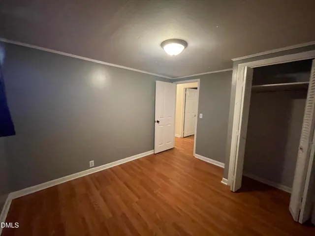 a view of an empty room with wooden floor