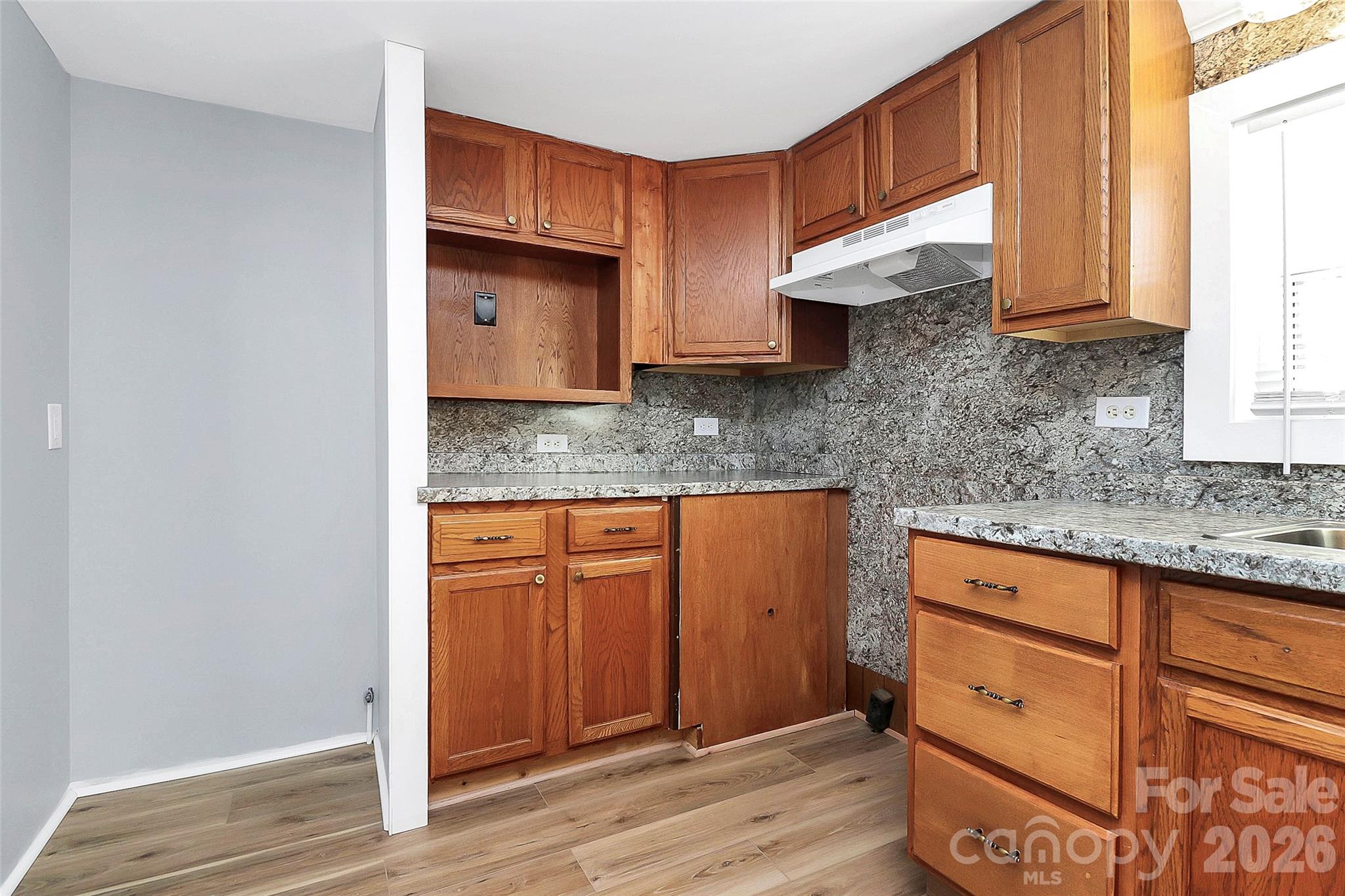 146 Swink Street Southwest Concord, NC 28027 - Photo 12 of 35 a kitchen with granite countertop wooden cabinets a sink and dishwasher