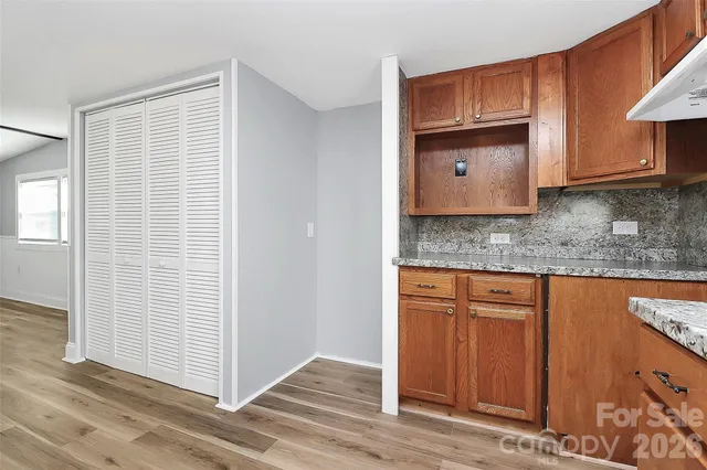 a kitchen with granite countertop wooden cabinets stainless steel appliances a sink and a window