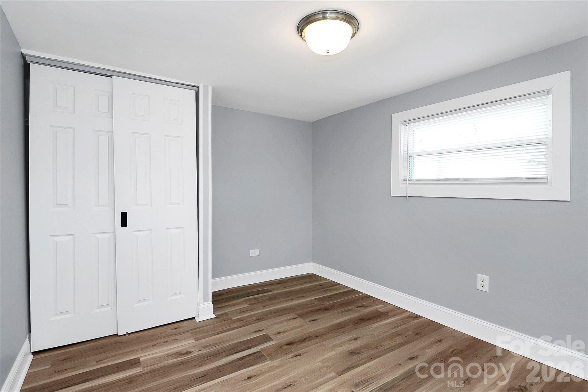 146 Swink Street Southwest Concord, NC 28027 - Photo 21 of 35 an empty room with wooden floor and windows
