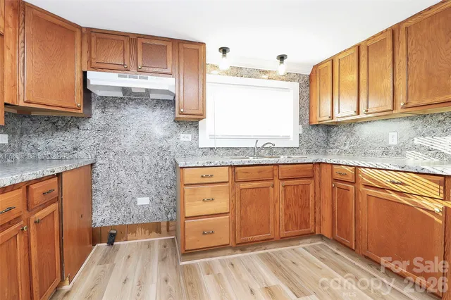 a kitchen with granite countertop cabinets and window