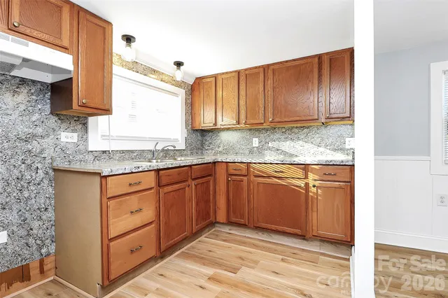 a kitchen with stainless steel appliances granite countertop wooden cabinets a sink and dishwasher