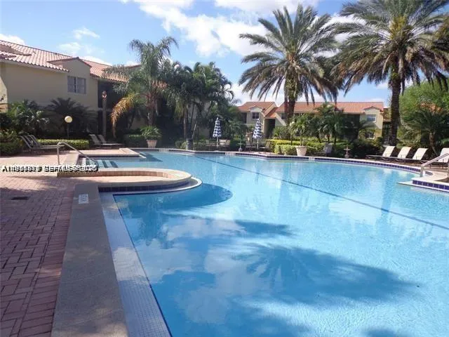 a view of swimming pool with palm trees