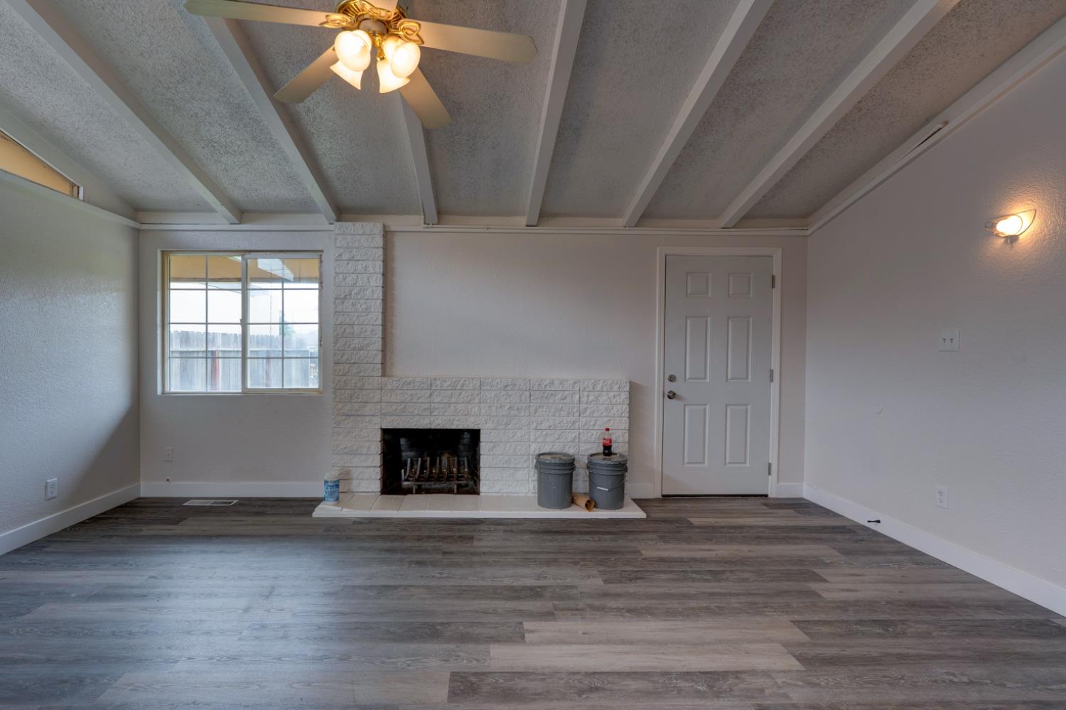 2310 Linden Street Atwater, CA 95301 - Photo 14 of 32 an empty room with wooden floor fireplace and windows