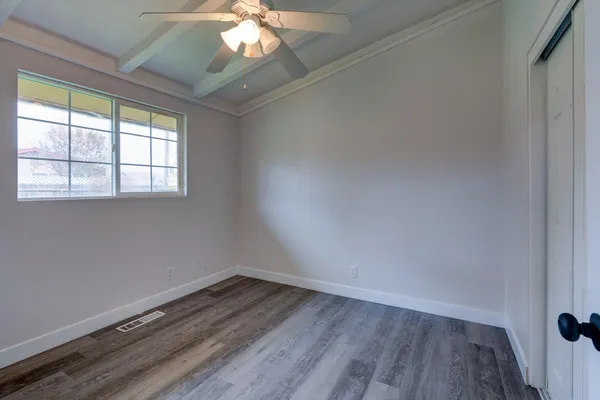 en empty room with wooden floor and windows