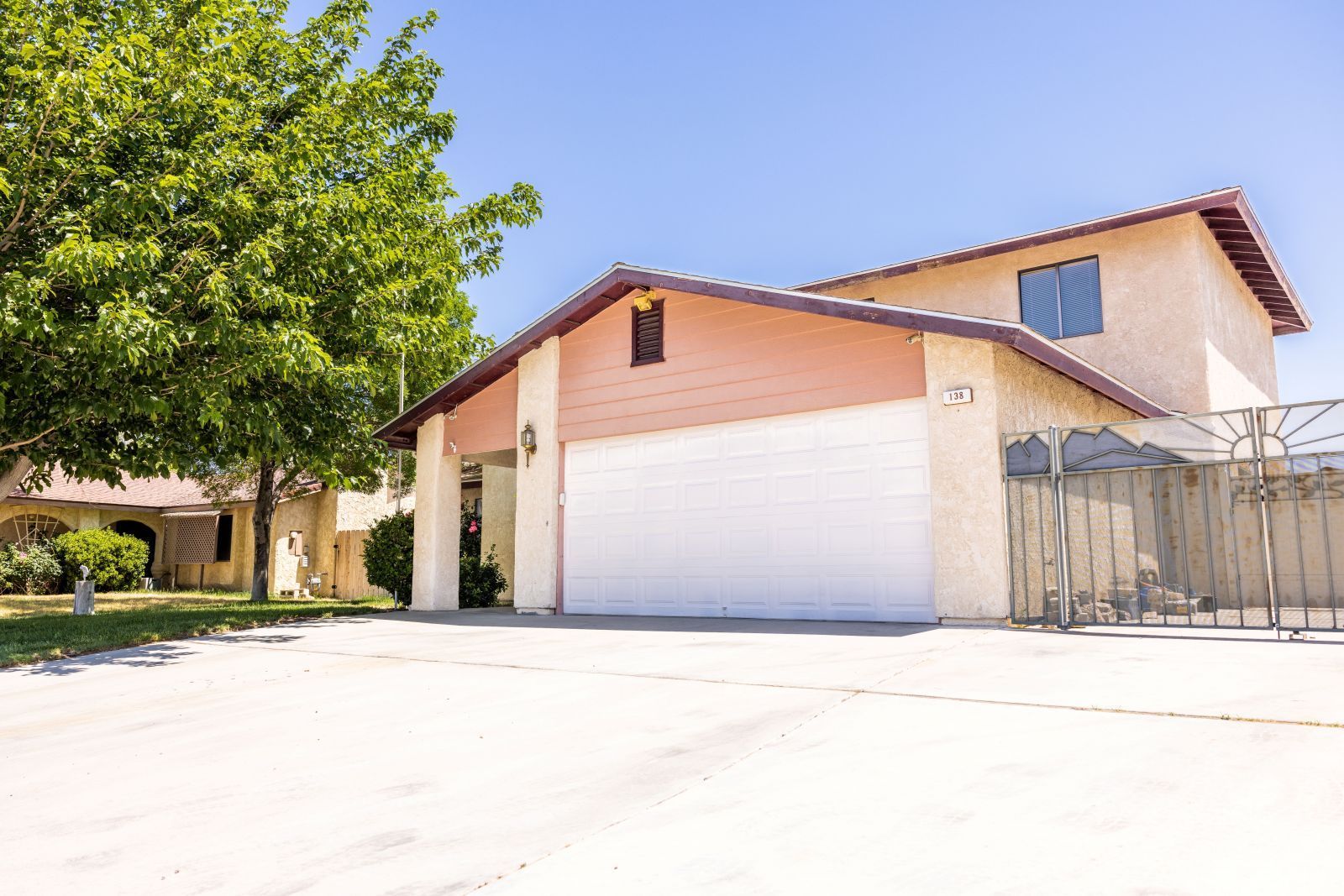 138 Chambers Street Ridgecrest, CA 93555 - Photo 2 of 28 a backyard of a house with garage and large trees