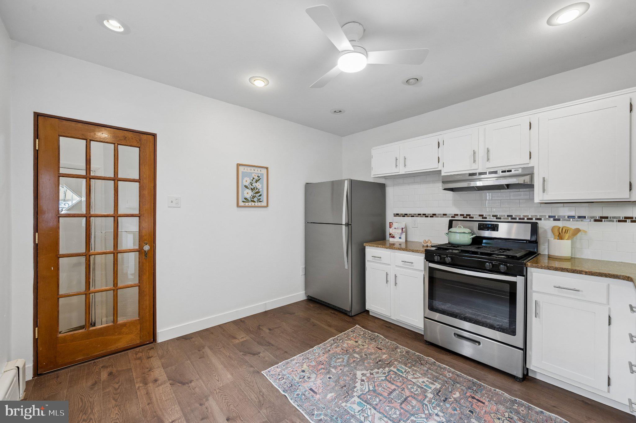3346 Edgemont Street Philadelphia, PA 19134 - Photo 14 of 25 a kitchen with a stove a refrigerator and white cabinets
