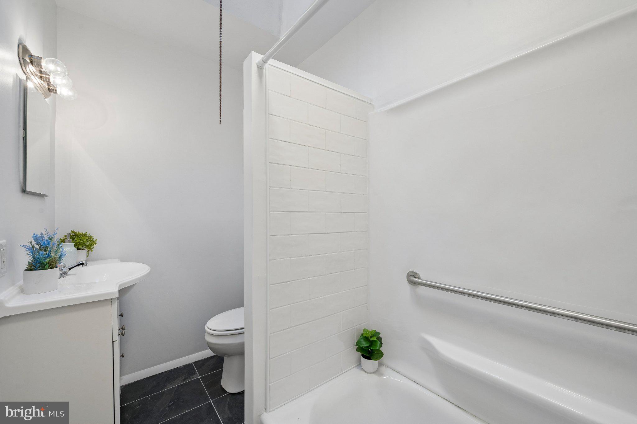 3346 Edgemont Street Philadelphia, PA 19134 - Photo 18 of 25 a bathroom with a sink a toilet and a shower