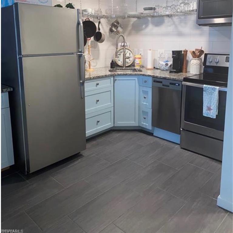 3 Bluebill Avenue, Unit 211 Naples, FL 34108 - Photo 5 of 8 a kitchen with cabinets and appliances