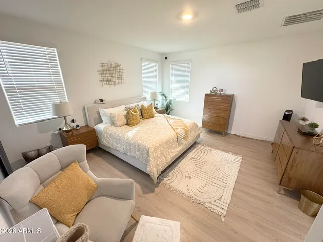 a bedroom with a bed a couch and dresser