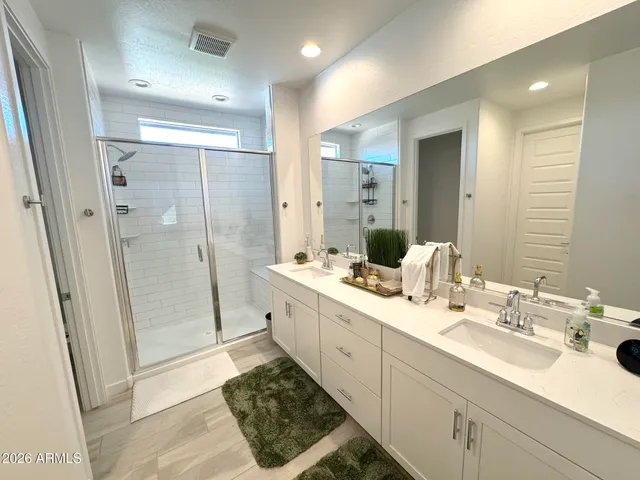 a bathroom with a double vanity sink mirror double and shower
