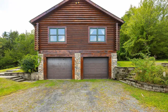 a backyard of a house with wooden fence and a large tree