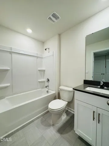 a bathroom with a granite countertop toilet a sink and a bathtub