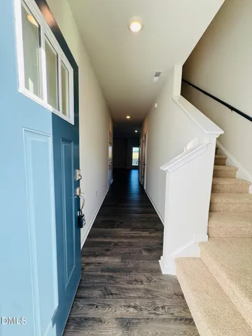 a view of staircase with lots of frames on wall and windows