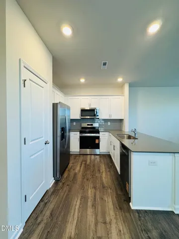 a kitchen with a refrigerator and a stove top oven