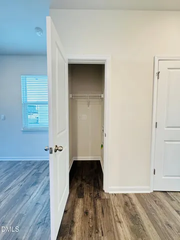 a view of a room with wooden floor and a bathroom