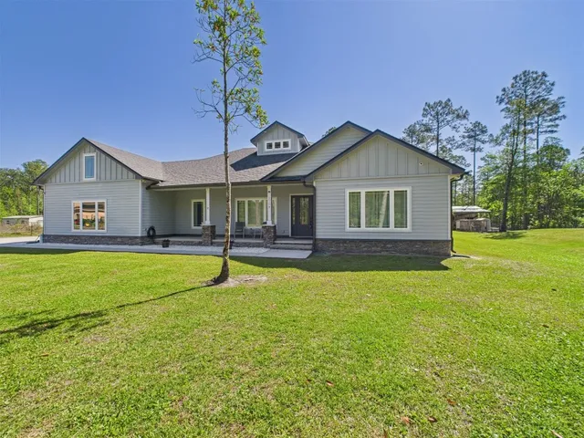 a dining room with wooden floor a chandelier a wooden table and chairs