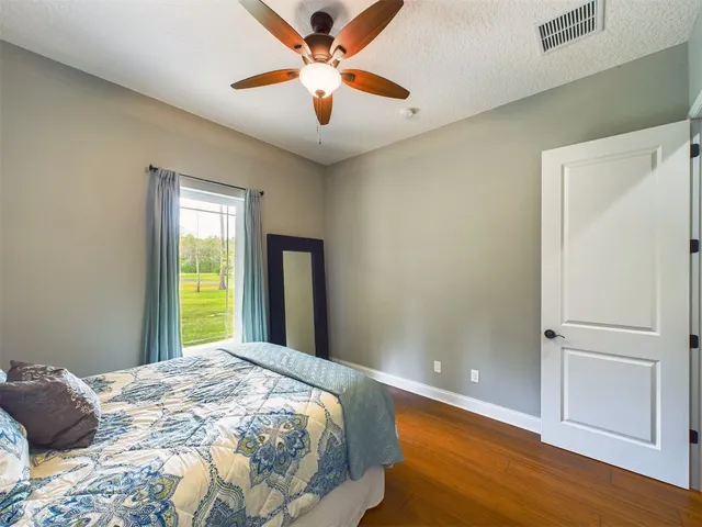 a view of a house with a big yard and large trees