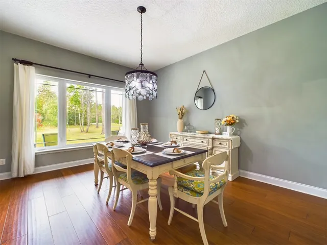 a view of a dining room with furniture wooden floor and chandelier
