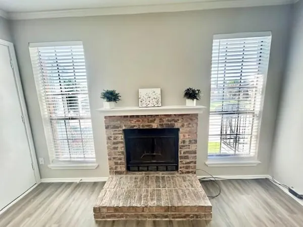 a living room with a fireplace and wooden floor