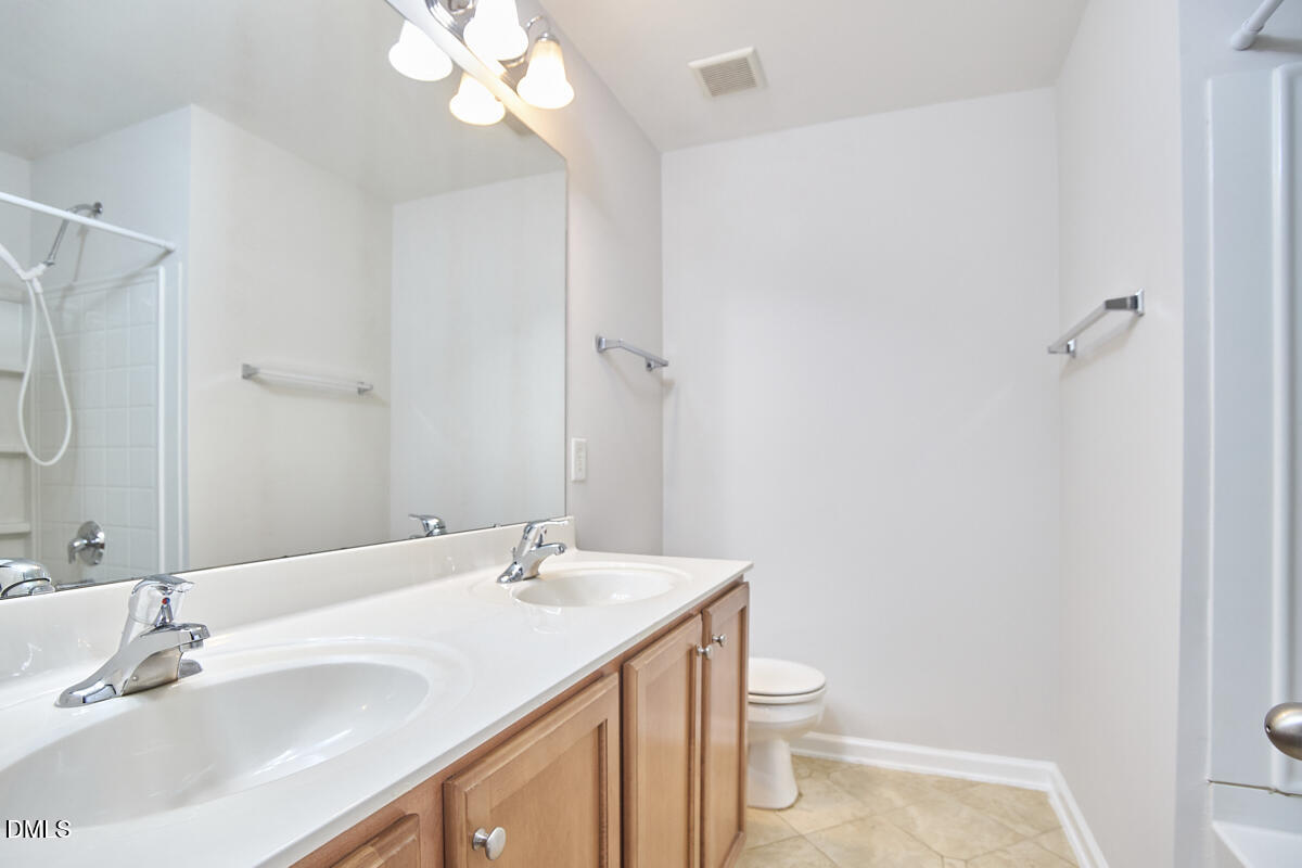 638 Cupola Drive Raleigh, NC 27603 - Photo 31 of 43 a bathroom with a granite countertop sink a toilet and a mirror