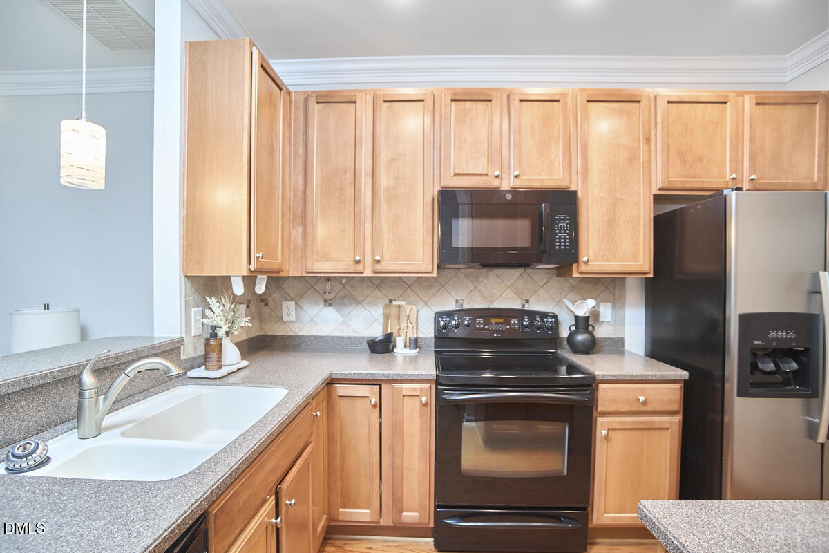 638 Cupola Drive Raleigh, NC 27603 - Photo 9 of 43 a kitchen with stainless steel appliances wooden cabinets stove and a granite counter top